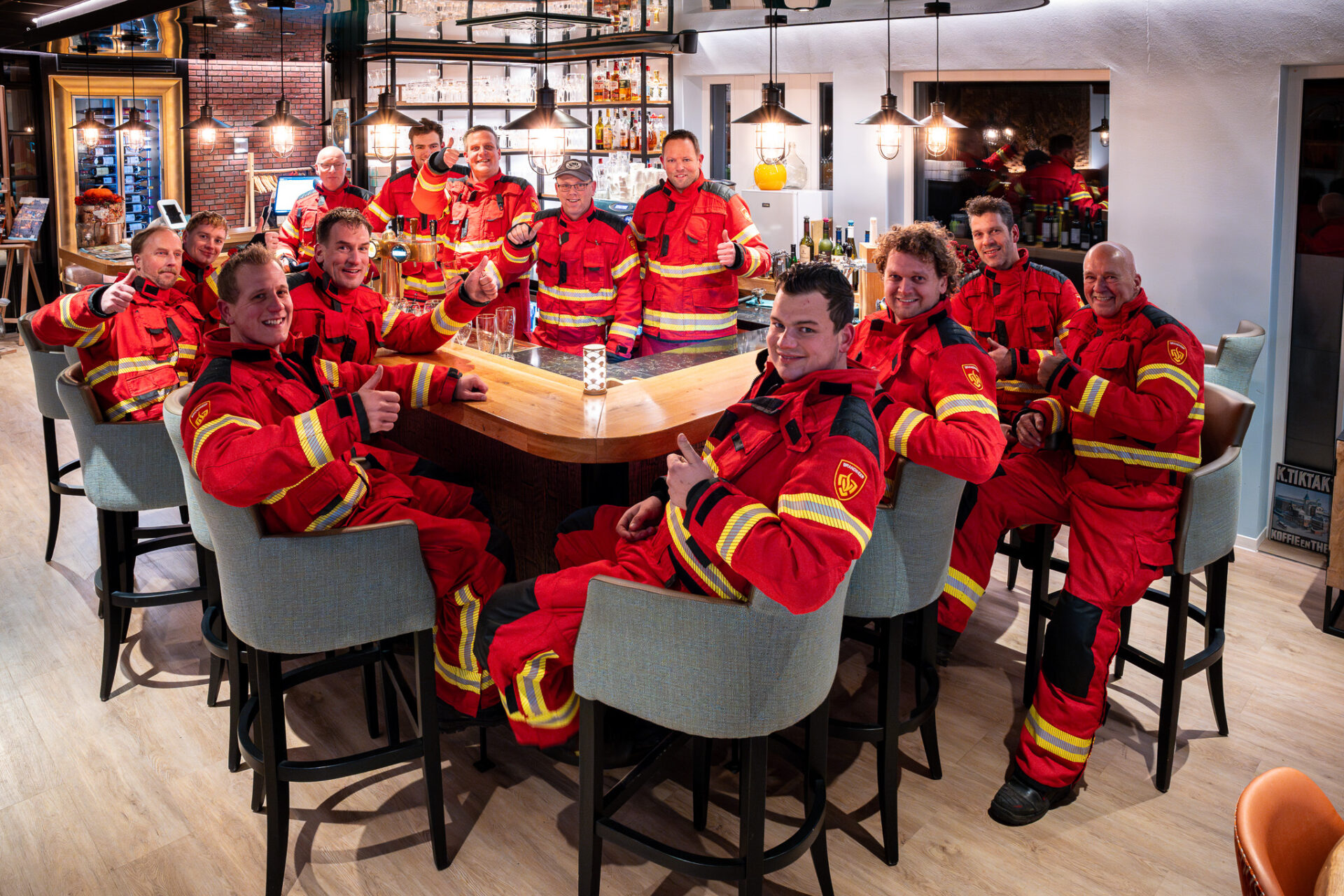 De brandweer van Woldendorp aan tafel in rood uitrukpak