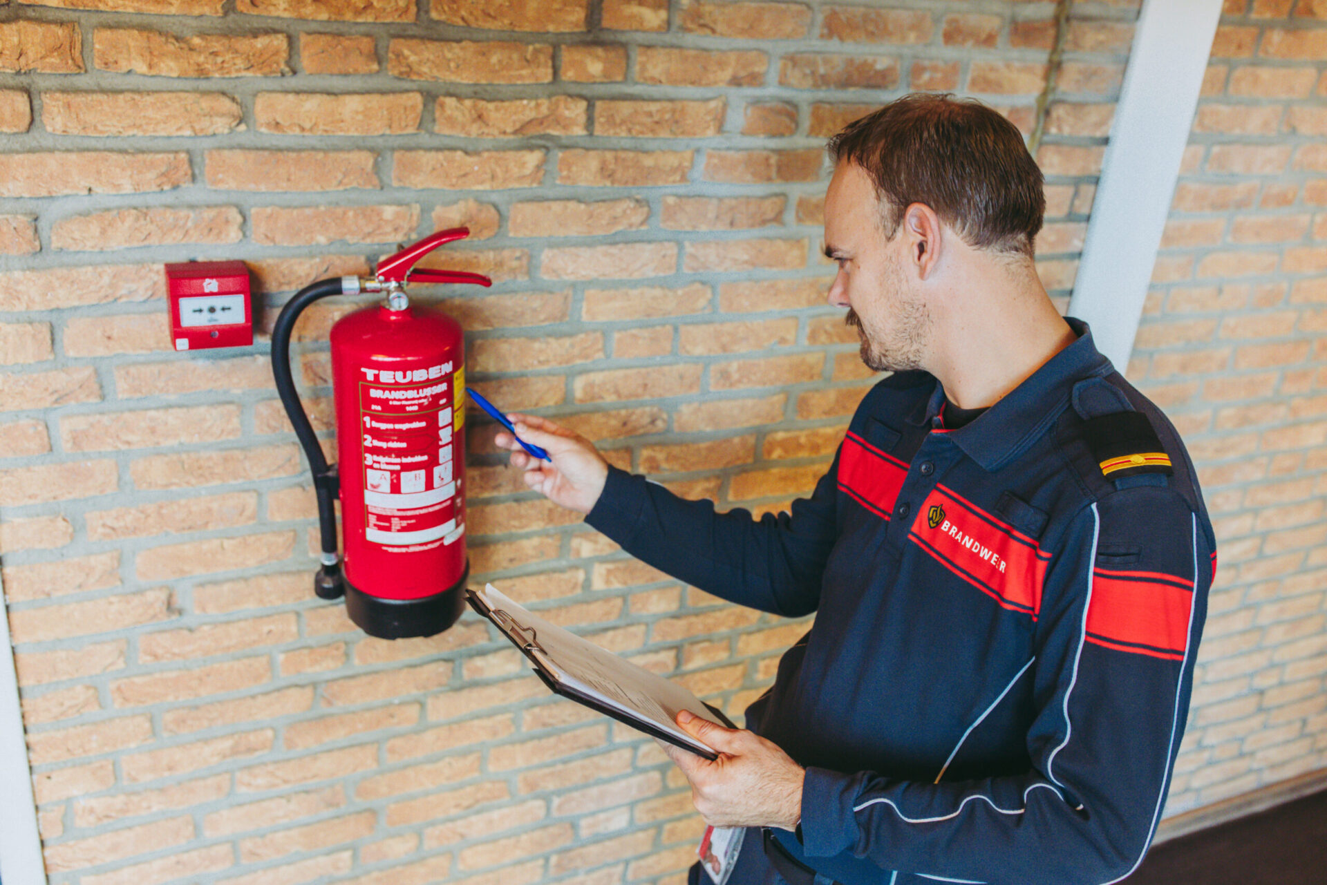brandweer toezichthouder controleert een brandblusser