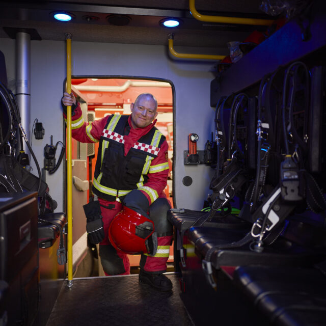 brandweerman die instapt in een brandweerauto